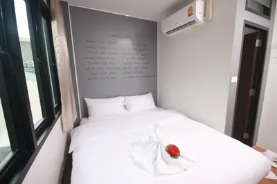 a bedroom with a white bed with a flower on it at Darin Hostel in Bangkok