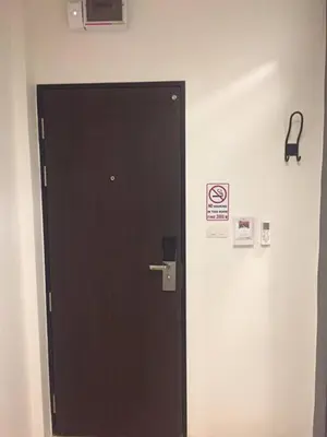 a black door with a sign on a wall at Darin Hostel in Bangkok