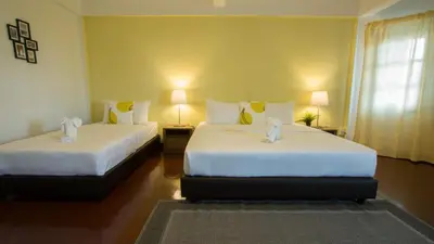 two beds in a room with two lamps at Neveu Premier Residence : Ratchada in Bangkok