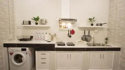 a kitchen with a sink and a washing machine at Neveu Premier Residence : Ratchada in Bangkok