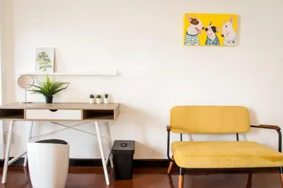 a chair next to a desk with a picture on the wall at Neveu Premier Residence : Ratchada in Bangkok