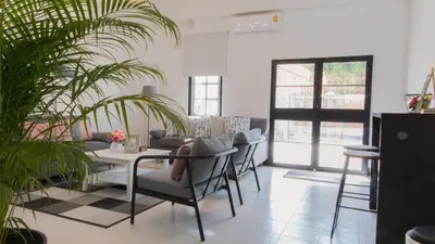 a living room with a table and chairs and plants at Neveu Premier Residence : Ratchada in Bangkok