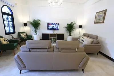a living room with couches and a flat screen tv at Neveu Premier Residence : Ratchada in Bangkok