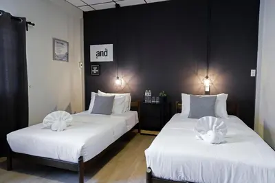 two beds in a room with white sheets at Neveu Premier Residence : Ratchada in Bangkok