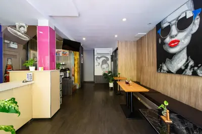 a restaurant with a table and a painting of a woman at BB House Phra Athit บีบี เฮ้าส์ พระอาทิตย์ in Bangkok