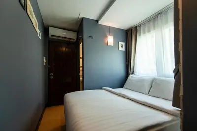 a small bedroom with a bed and a window at BB House Phra Athit บีบี เฮ้าส์ พระอาทิตย์ in Bangkok