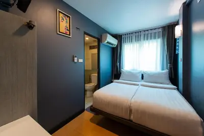 a bedroom with a bed with a window and a toilet at BB House Phra Athit บีบี เฮ้าส์ พระอาทิตย์ in Bangkok