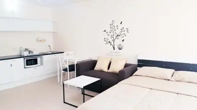 a living room with a bed and a kitchen at Popular Condo C8 in Nonthaburi