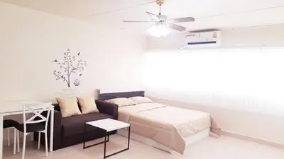 a bedroom with a bed and a couch and a table at Popular Condo C8 in Nonthaburi