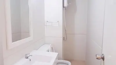 a white bathroom with a sink and a toilet at Popular Condo C8 in Nonthaburi
