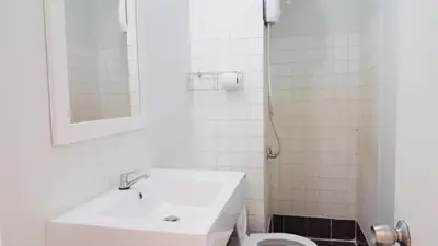 a white bathroom with a sink and a toilet at Popular Condo C6 in Nonthaburi