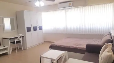 a bedroom with a bed and a desk and a table at Popular Condo P1 in Nonthaburi