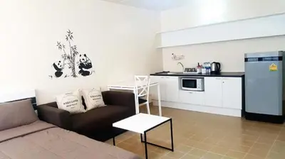 a living room with a couch and a kitchen at Popular Condo P1 in Nonthaburi