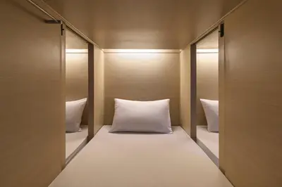a room with a bed with two pillows at ORA Hostel Bangkok in Bangkok