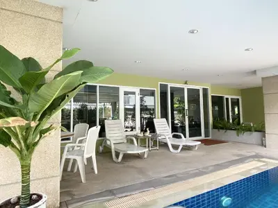 a patio with chairs and a table and a pool at 14 Place Sukhumvit Suites in Bangkok