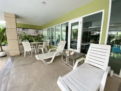 a patio with white chairs and a table and chairs at 14 Place Sukhumvit Suites in Bangkok