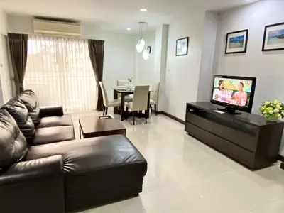 a living room with a couch and a television at 14 Place Sukhumvit Suites in Bangkok