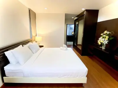 a bedroom with a large white bed with white pillows at 14 Place Sukhumvit Suites in Bangkok