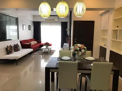 a dining room and living room with a table and chairs at 14 Place Sukhumvit Suites in Bangkok