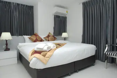 a bedroom with a large bed with white sheets and pillows at Top High Airport Link Hotel, Bangkok in Bangkok