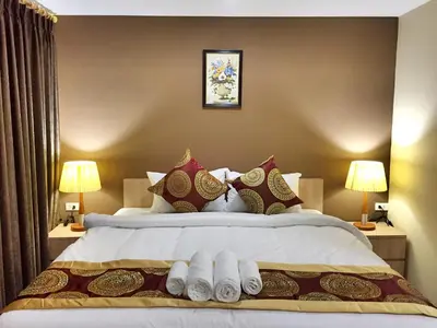a bedroom with a large bed with towels on it at Top High Airport Link Hotel, Bangkok in Bangkok