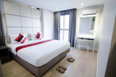 a bedroom with a large white bed with red pillows at Hope Land Hotel Sukhumvit 8 in Bangkok