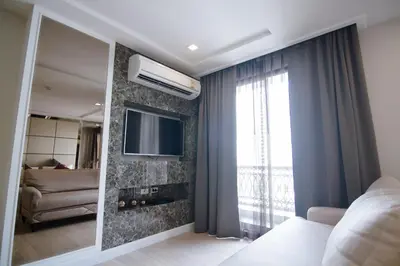 a bedroom with a mirror and a tv and a couch at Hope Land Hotel Sukhumvit 8 in Bangkok