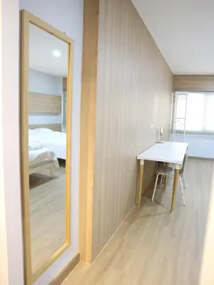 a mirror in a room with a table and a bed at Boon Street Hostel in Bangkok