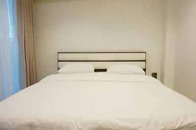 a white bed with white sheets and pillows at Boon Street Hostel in Bangkok