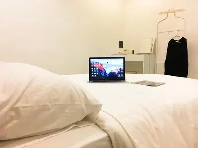 a laptop computer sitting on top of a bed at Boon Street Hostel in Bangkok