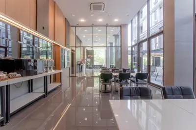 a restaurant with chairs and tables in a building at Kepler Residence Bangkok in Bangkok