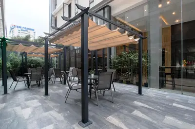 a restaurant with tables and chairs under awning on a building at Kepler Residence Bangkok in Bangkok
