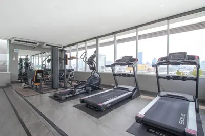a gym with treadmills and ellipticals in a building at Kepler Residence Bangkok in Bangkok