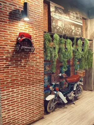 a motorcycle is parked next to a brick wall at Yotaka The Hostel in Bangkok