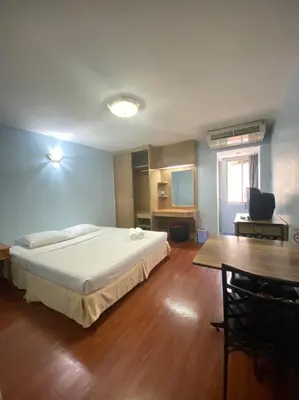 a bedroom with a large bed and a table at City Residence in Bangkok