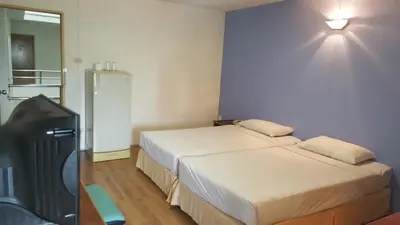 a hotel room with two beds and a flat screen tv at City Residence in Bangkok