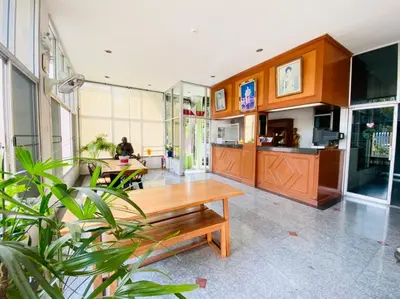 a lobby with a wooden table and some plants at City Residence in Bangkok