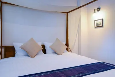 a bedroom with a bed with white sheets and pillows at Neighbor Phuthon in Bangkok