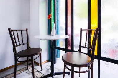 two chairs and a table in front of a window at Neighbor Phuthon in Bangkok