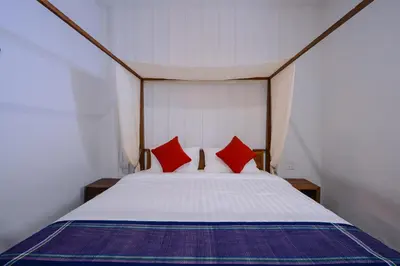 a bedroom with a bed with two red pillows at Neighbor Phuthon in Bangkok