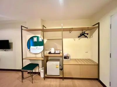 a small room with a small refrigerator and a kitchen at Klean Residence Hotel in Bangkok