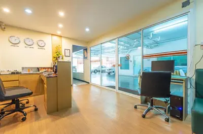 an office with a desk and two chairs in a room at Klean Residence Hotel in Bangkok
