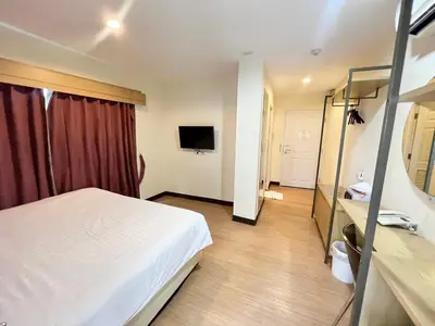 a hotel room with a bed and a television at Klean Residence Hotel in Bangkok
