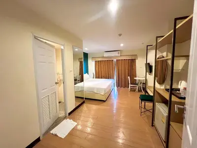 a bedroom with a bed and a room with a mirror at Klean Residence Hotel in Bangkok