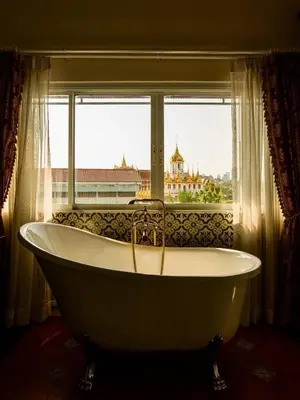 a bath tub sitting in front of a window at Siam Champs Elyseesi Unique Hotel in Bangkok