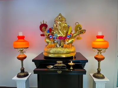 a gold statue sitting on a table with two lamps at Siam Champs Elyseesi Unique Hotel in Bangkok