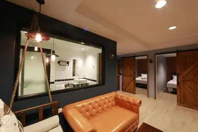 a living room with a couch and a mirror at Adagio Bangkok in Bangkok
