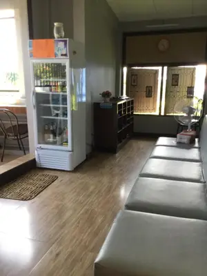 a room with a refrigerator and a row of seats at Donmuang At Last in Bangkok
