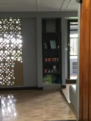 a living room with a wall with a window and a couch at Donmuang At Last in Bangkok