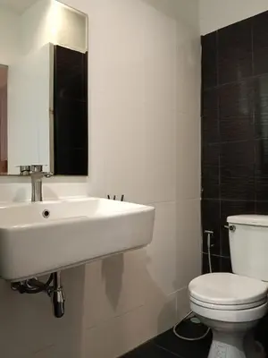 a bathroom with a white sink and a toilet at Rabbit Room in Bangkok